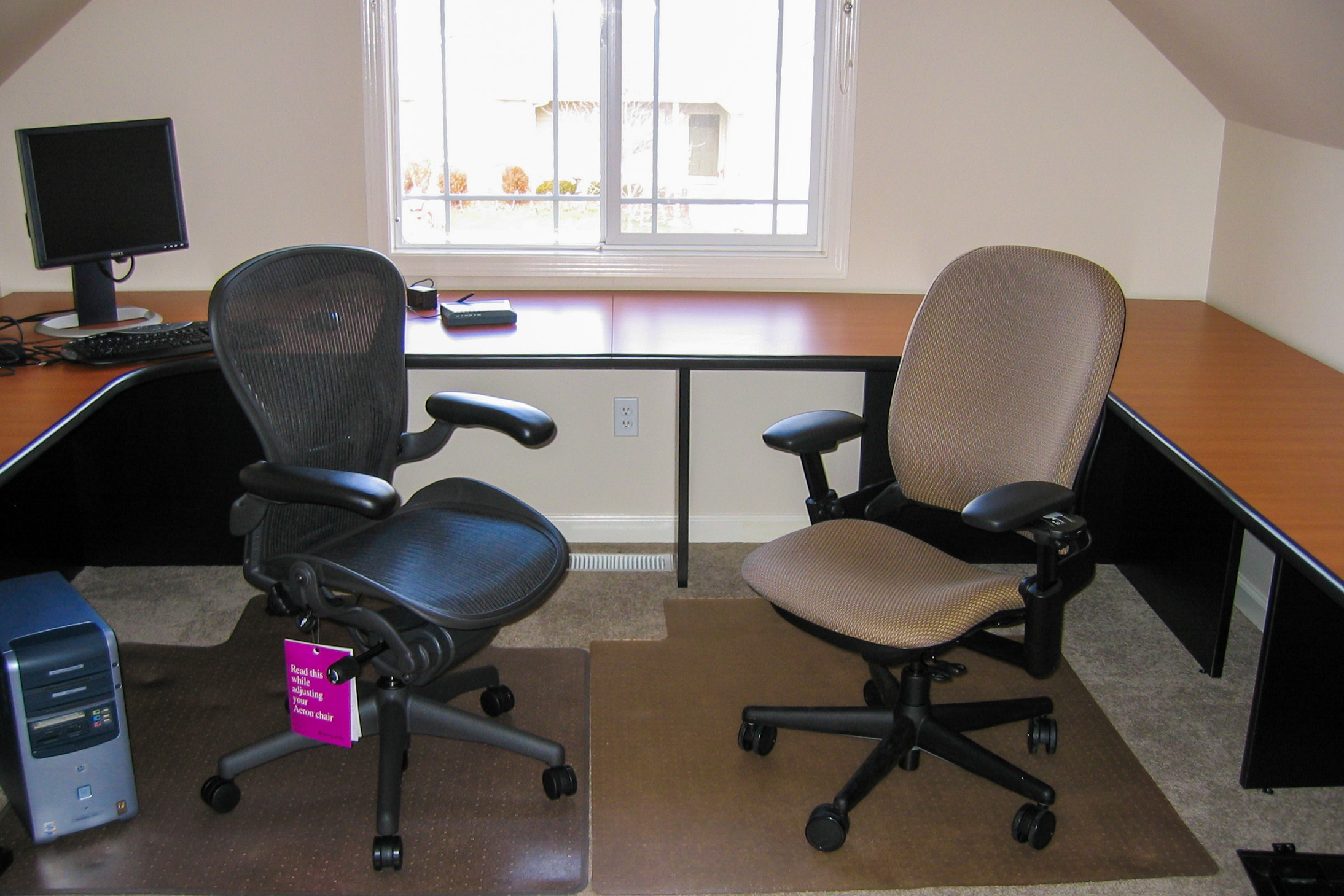 Herman Miller Aeron and Steelcase Leap chairs in front of empty home office