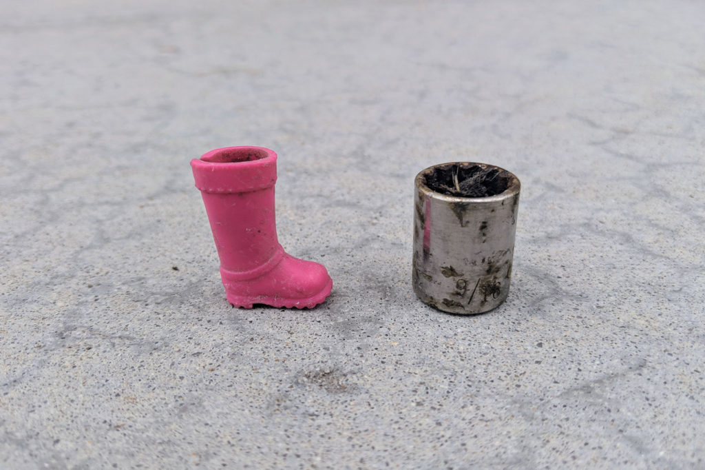Tiny pink toy boot and a dirty 9/16" socket
