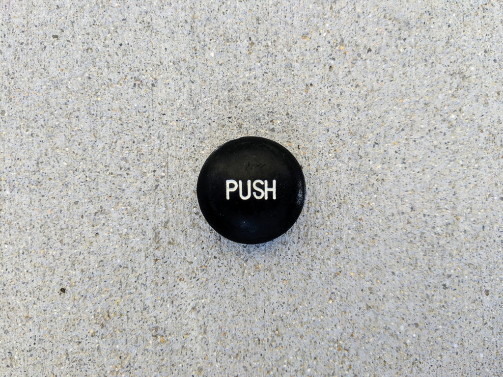 Black button with the label "PUSH" on it