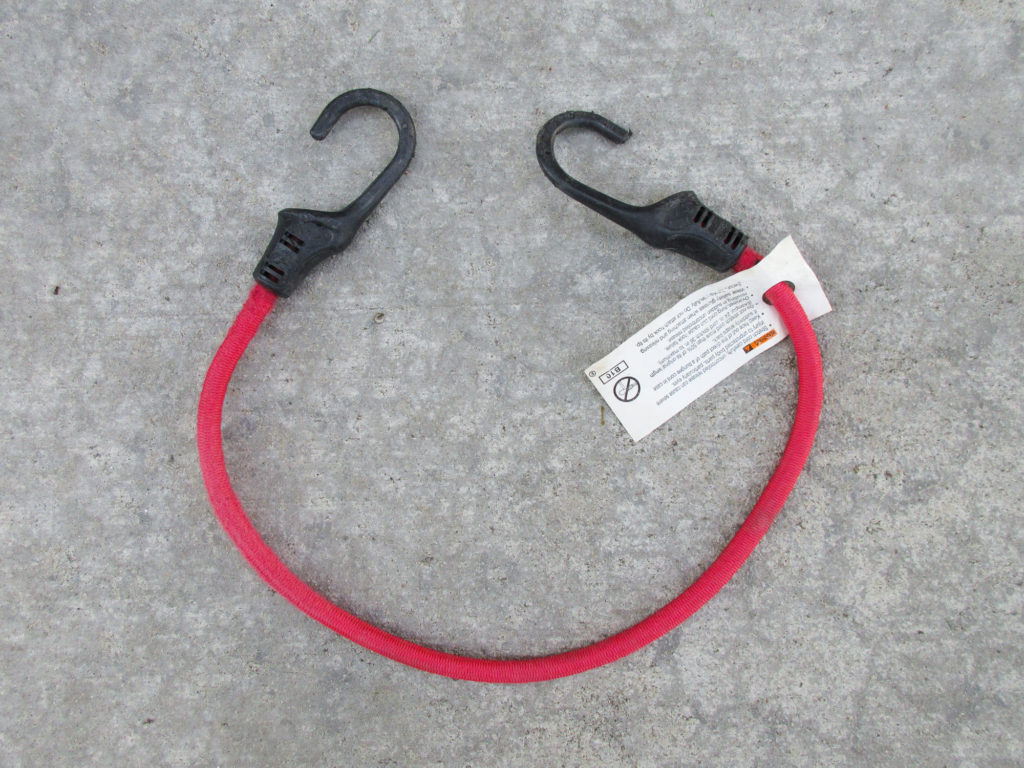 Red bungee cord with safety tag still attached