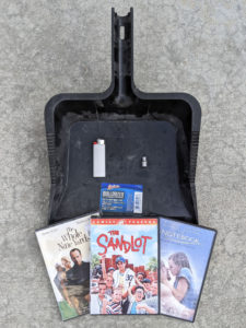 Heavy duty dust pan, white BIC lighter, 6mm socket, and three DVDs: The Whole Nine Yards, The Sandlot, and The Notebook