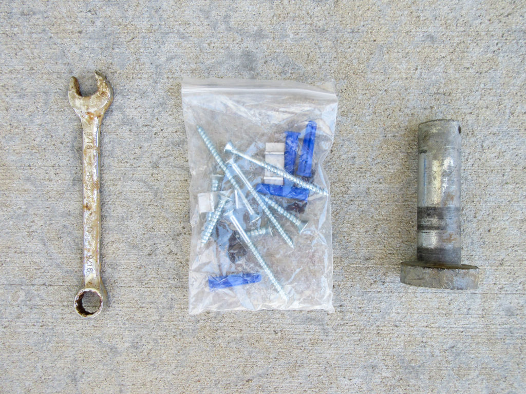 9/16" open end wrench, wall screw set, and a large steel clevis pin.