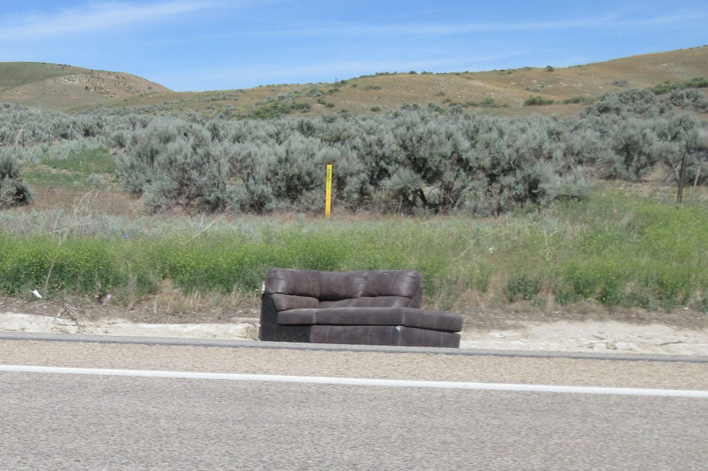 Brown sectional couch on the side of the road
