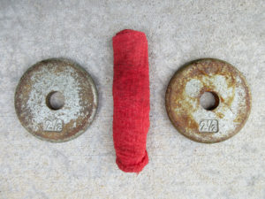 Two 2.5lbs. standard weight plates and a red work rag