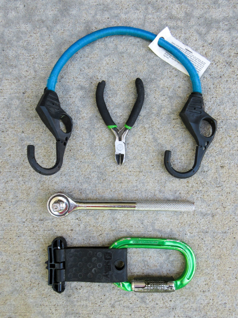 Blue bungee cord, mini diagonal cutters, 3/8" drive socket wrench, green carabiner