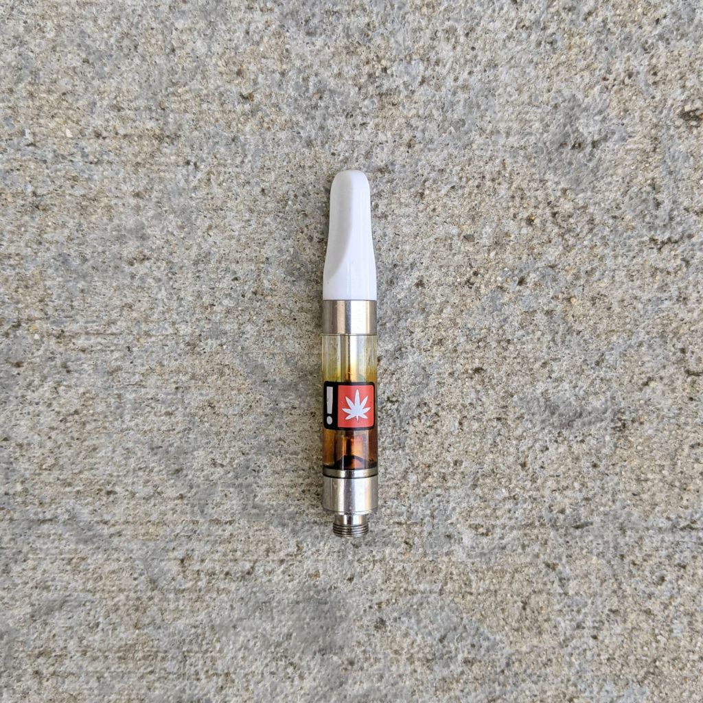 Empty vape cartridge with sticker of an exclamation point and marijuana leaf