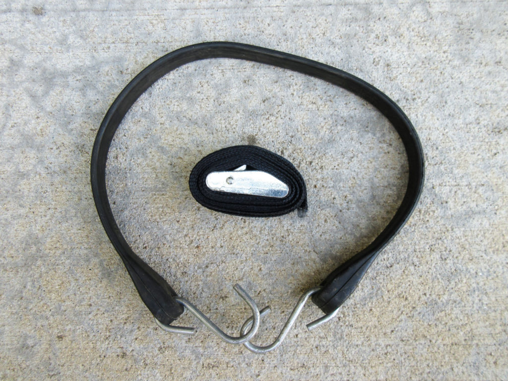 Black rubber tarp strap and a black web tie-down strap