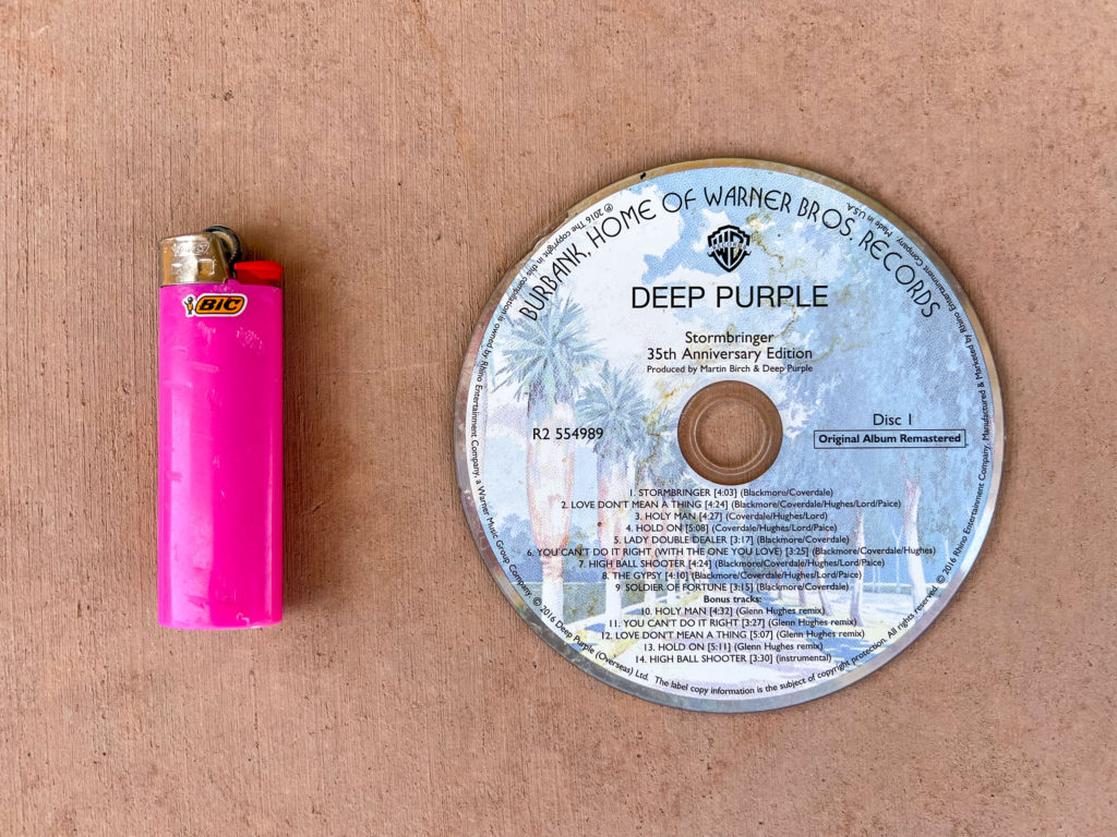 Pink BIC lighter and Deep Purple Stormbringer music CD.
