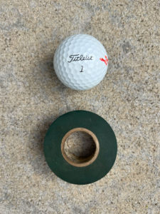 Titleist golf ball and roll of green Scotch electrical tape