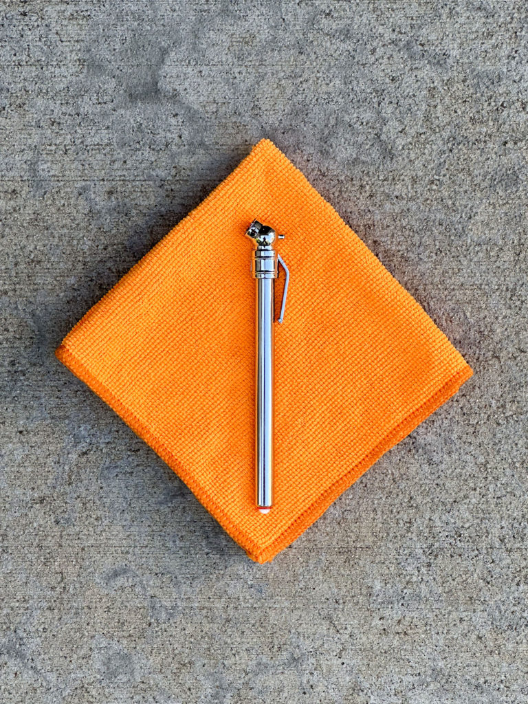 Pencil tire pressure gauge on a folded orange microfiber cloth