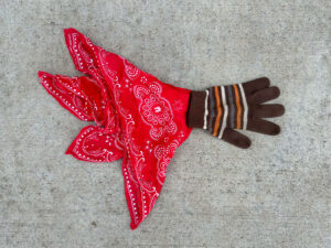 Red bandana and a knitted brown glove with stripes