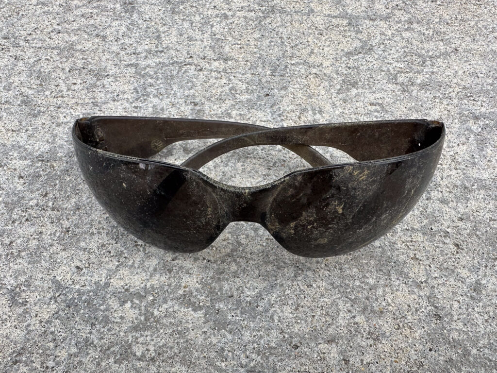 Tinted outdoor safety glasses lightly covered in dirt