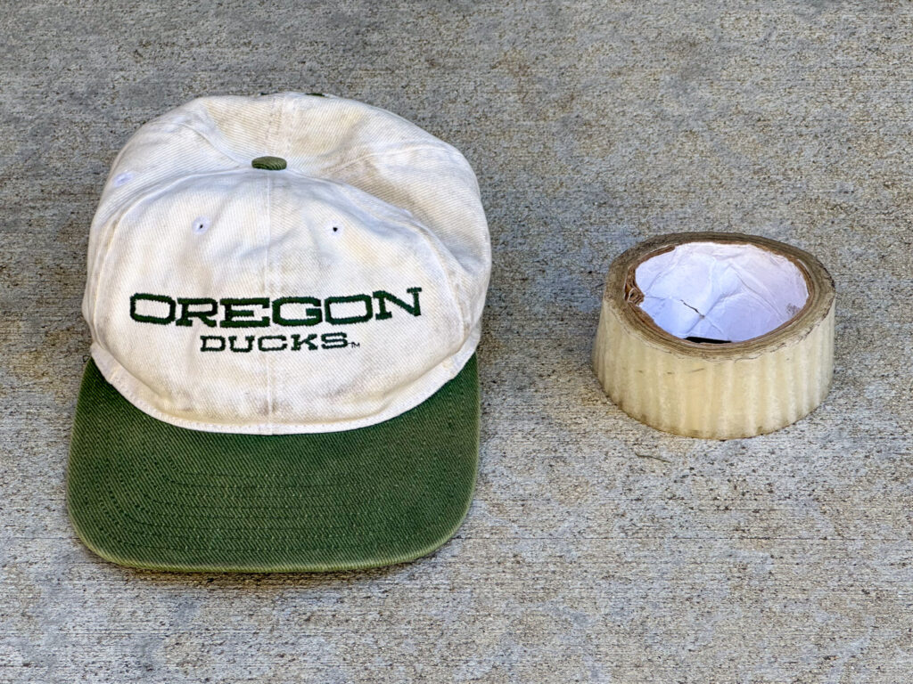 Oregon Ducks hat and a tattered roll of clear packing tape