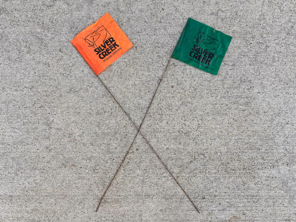 Orange and green sprinkler flags with "Silver Creek" logo