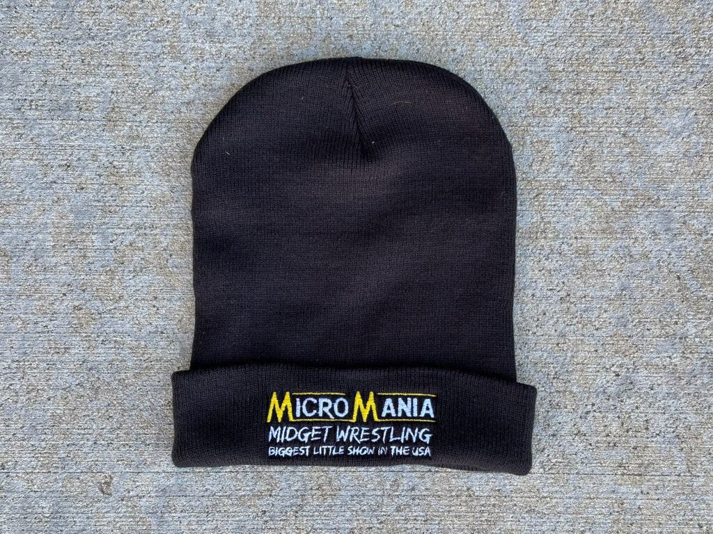 Black winter hat embroidered with "Micro Mania, Midget Wrestling, Biggest Little Show in the USA"
