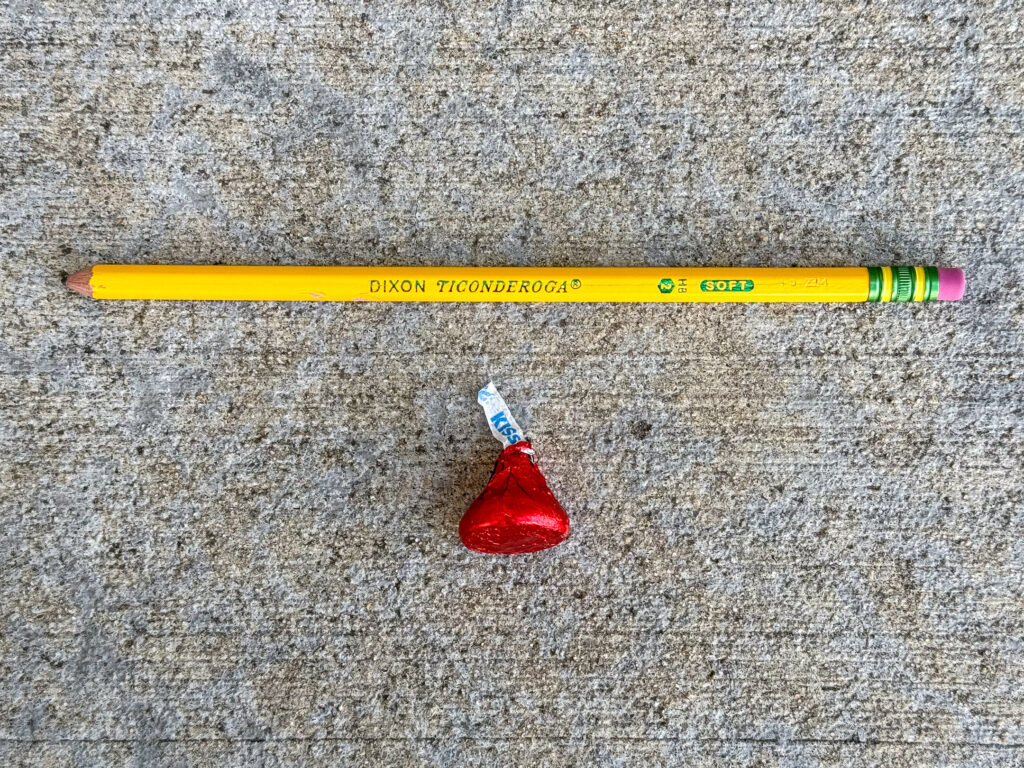 Dixon yellow pencil and a red foil-wrapped Hershey's Kiss
