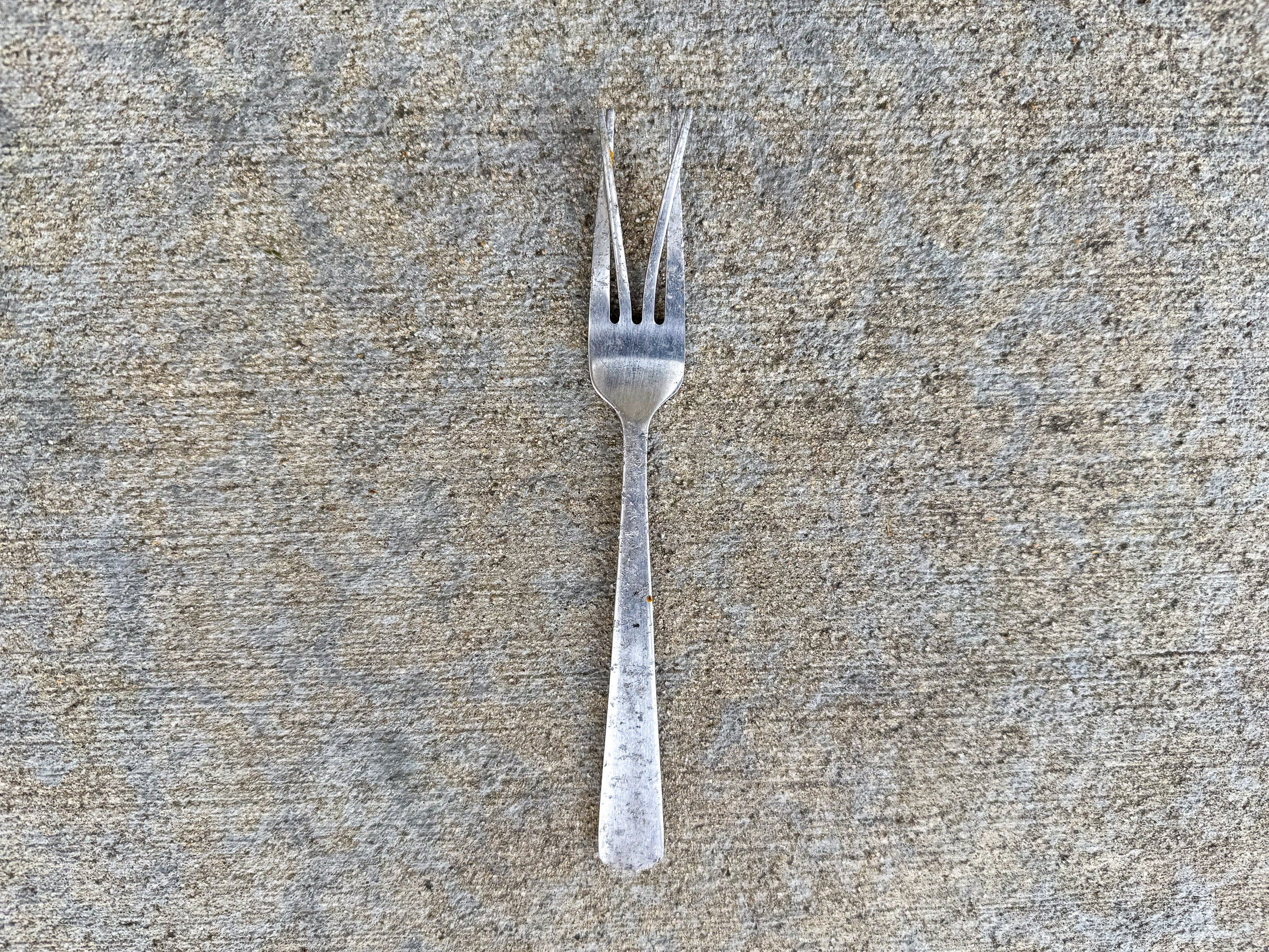 Weathered four-tined fork with the middle two tines bent outward
