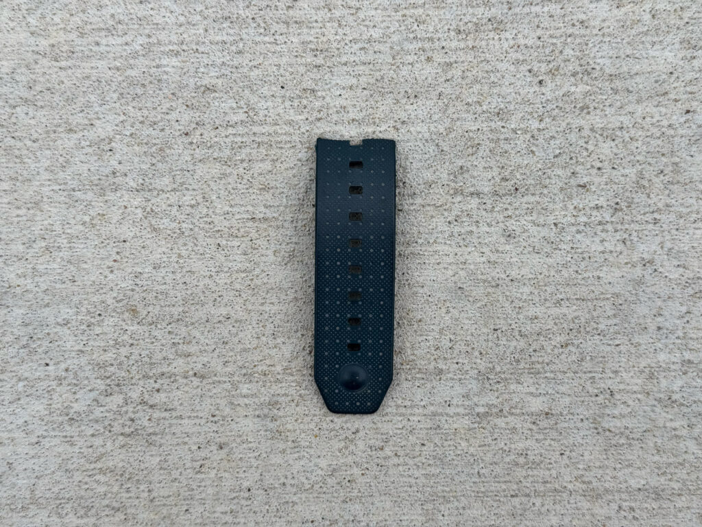 Torn bottom half of a dark gray watch band