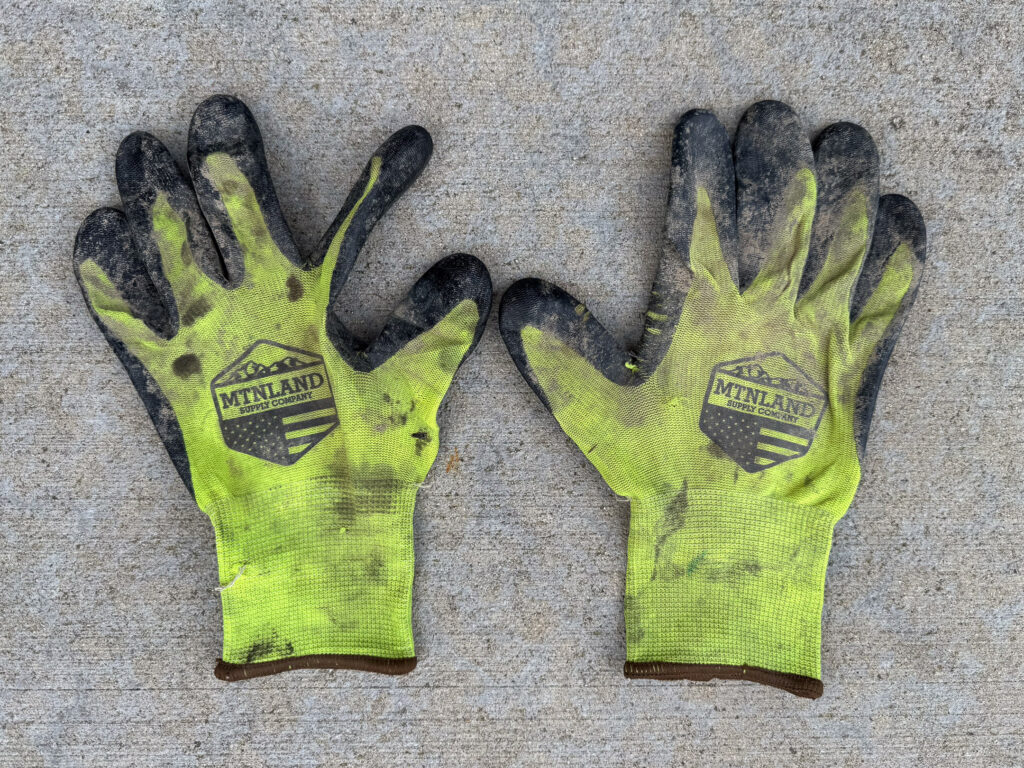 Soiled pair of florescent yellow work gloves